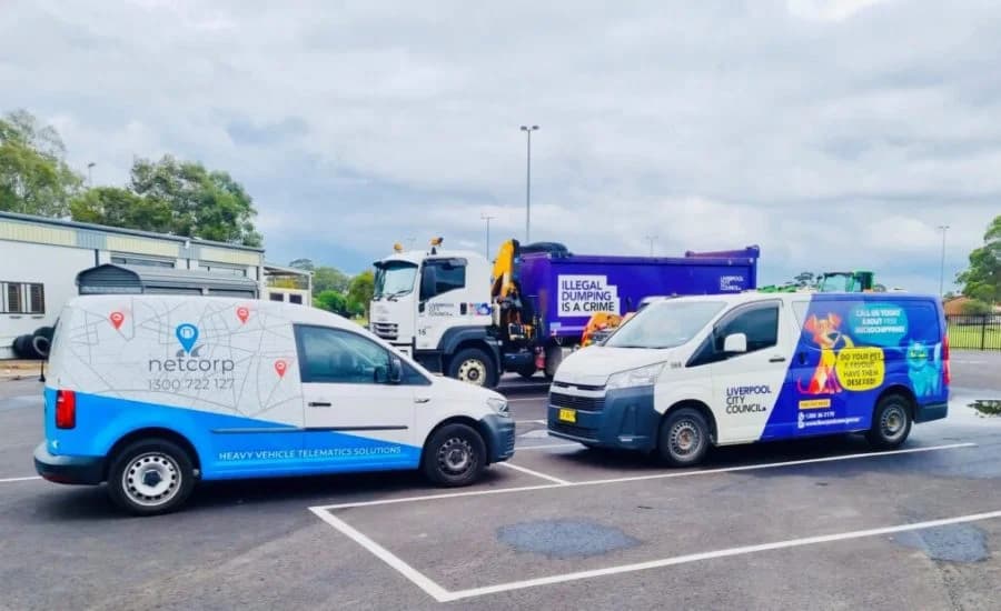 A Netcorp technician fitting a hardwired tracker to a fleet vehicle at a depot